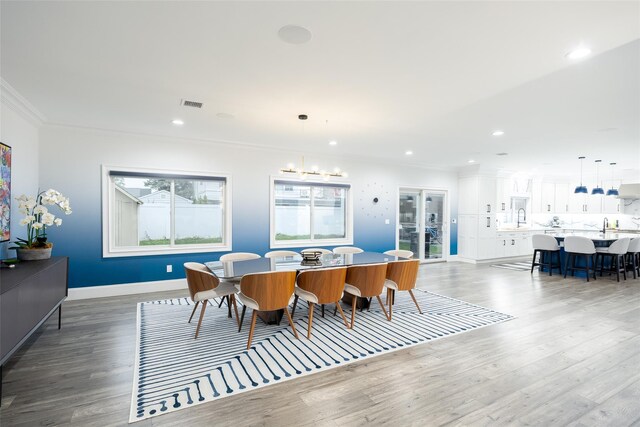 18 Heron Ct, Levittown, NY 11756 - dining space featuring ornamental molding, wood finished floors, baseboards, recessed lighting, and a chandelier