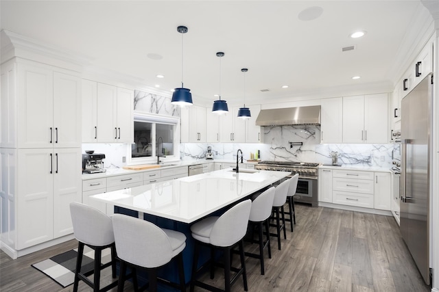 18 Heron Ct, Levittown, NY 11756 - kitchen with premium appliances, wall chimney exhaust hood, decorative backsplash, a kitchen breakfast bar, and light countertops