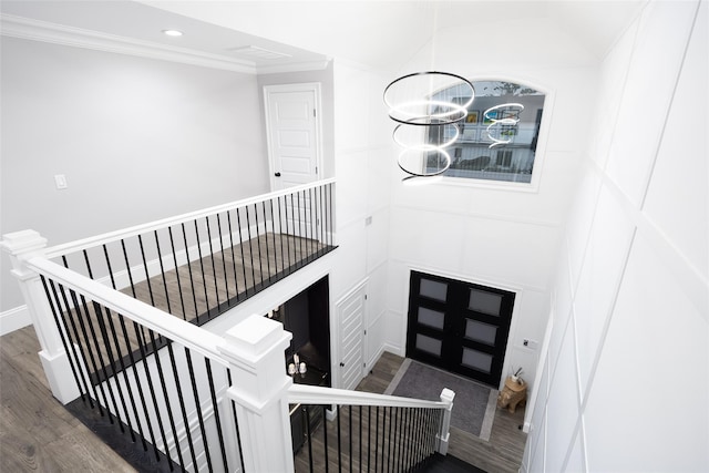 18 Heron Ct, Levittown, NY 11756 - stairs featuring wood finished floors, crown molding, recessed lighting, a decorative wall, and a chandelier