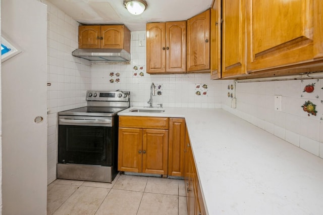 435 S Columbus Ave, Mount Vernon, NY 10553 - kitchen featuring stainless steel range with electric stovetop, a sink, under cabinet range hood, light countertops, and brown cabinets
