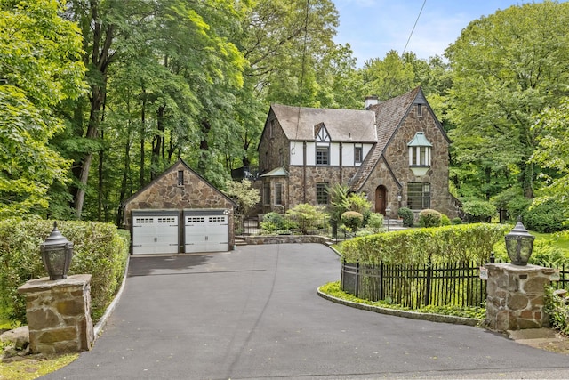 100 Mount Airy Rd S, Croton-On-Hudson, NY 10520 - tudor-style house with stone siding, a detached garage, an outdoor structure, and a chimney
