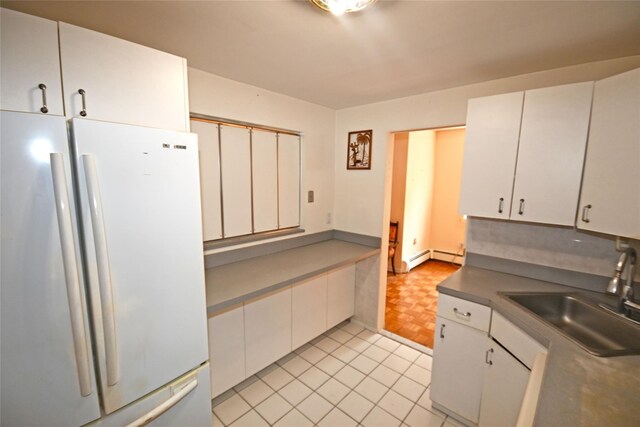 10 Ipswich Ave Unit 4M, Great Neck, NY 11021 - kitchen with freestanding refrigerator, white cabinets, baseboard heating, and dark countertops