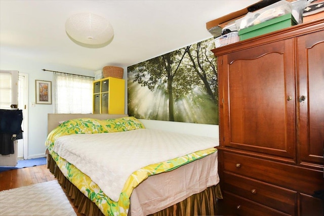 bedroom featuring wood finished floors and baseboards