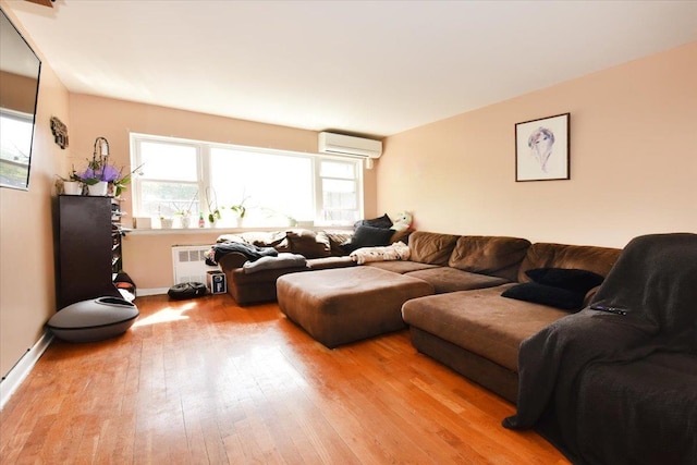 living area with a wall unit AC, radiator, light wood-type flooring, and baseboards