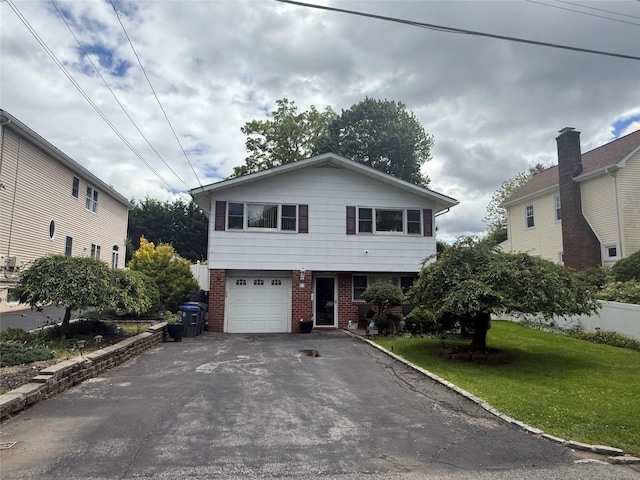 31 Stevenson Ave, Hartsdale, NY 10530 - view of front facade with brick siding, an attached garage, asphalt driveway, and a front lawn