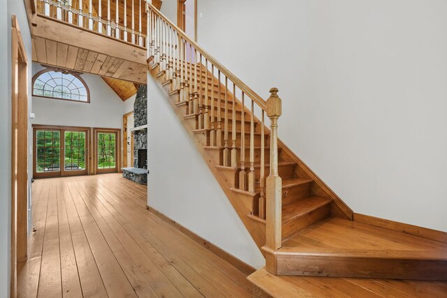6843 Rte 55, Wingdale, NY 12594 - stairway with a fireplace, a high ceiling, hardwood / wood-style floors, and baseboards
