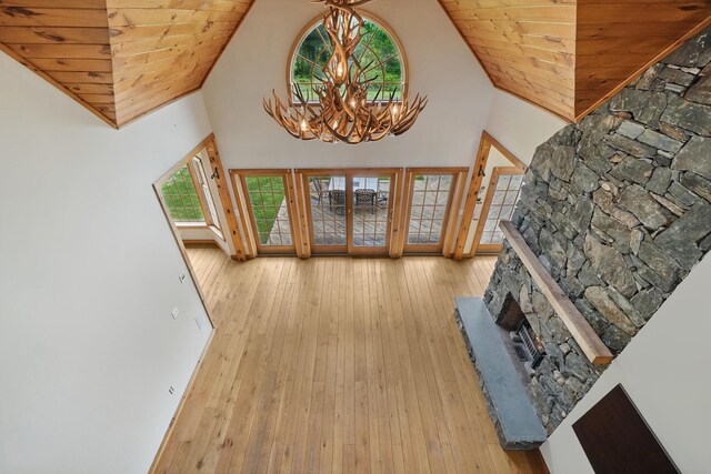 6843 Rte 55, Wingdale, NY 12594 - living area with hardwood / wood-style flooring, a chandelier, high vaulted ceiling, a stone fireplace, and baseboards