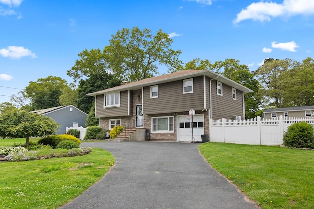 176 Harrison Ave, Miller Place, NY 11764 - raised ranch featuring asphalt driveway, a garage, and stone siding