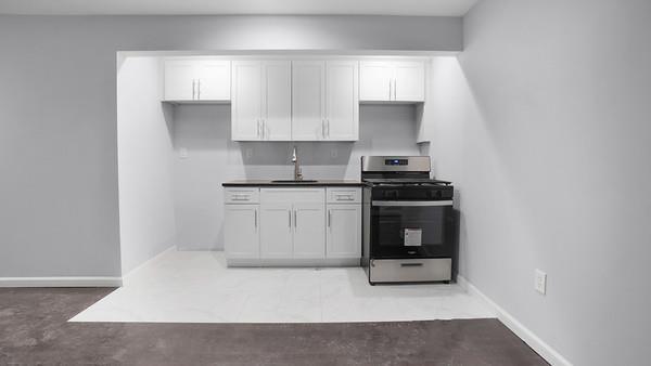2040 Washington Ave, Bronx, NY 10457 - kitchen with stainless steel gas range oven, a sink, white cabinets, and baseboards