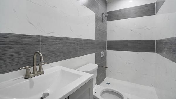 2040 Washington Ave, Bronx, NY 10457 - bathroom with toilet, tiled shower, tile walls, and vanity