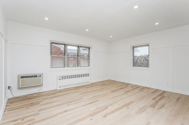 189 Drake Ave Unit 2A, New Rochelle, NY 10805 - spare room featuring radiator, wood finished floors, a wall unit AC, a decorative wall, and recessed lighting