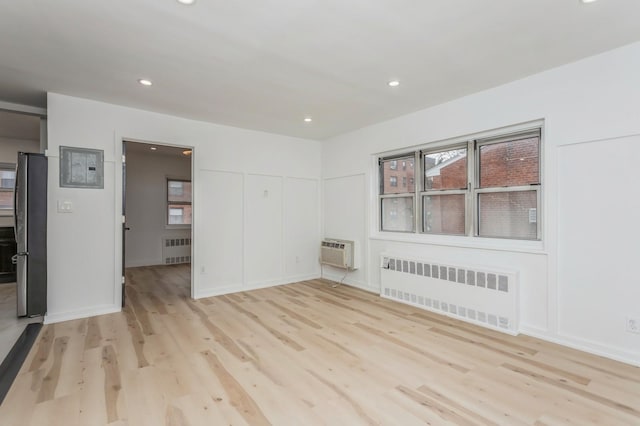 189 Drake Ave Unit 2A, New Rochelle, NY 10805 - spare room featuring radiator, light wood-type flooring, recessed lighting, and an AC wall unit