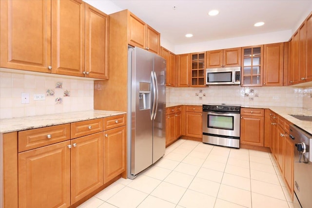 100 Harbor View Dr SW Unit 335, Port Washington, NY 11050 - kitchen with stainless steel appliances, light stone counters, decorative backsplash, glass insert cabinets, and a sink