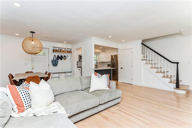 living room with light wood-style floors, stairs, recessed lighting, crown molding, and baseboards