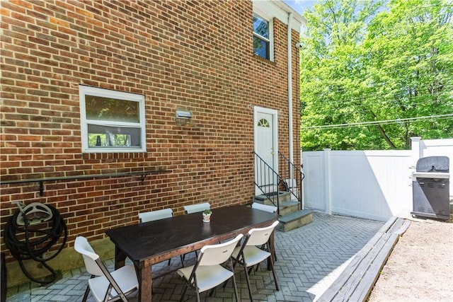 view of patio / terrace featuring entry steps, fence, and outdoor dining area