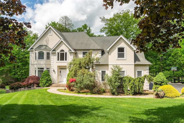 9 Golf Course Dr, Suffern, NY 10901 - view of front facade with stucco siding, a front yard, and roof with shingles