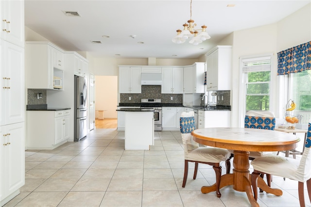 9 Golf Course Dr, Suffern, NY 10901 - kitchen with stainless steel appliances, a chandelier, backsplash, a sink, and premium range hood