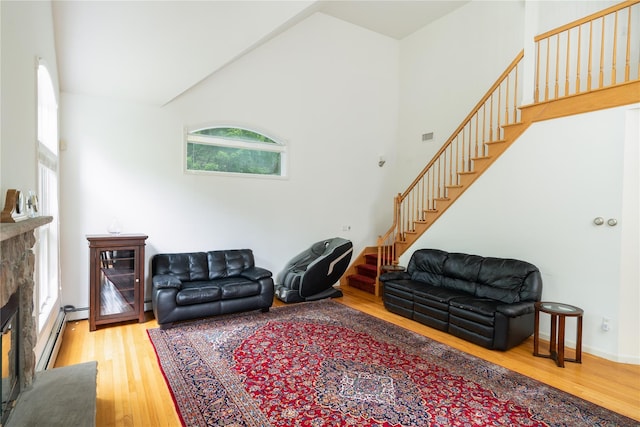 9 Golf Course Dr, Suffern, NY 10901 - living area with stairway, wood finished floors, a fireplace, a baseboard radiator, and high vaulted ceiling