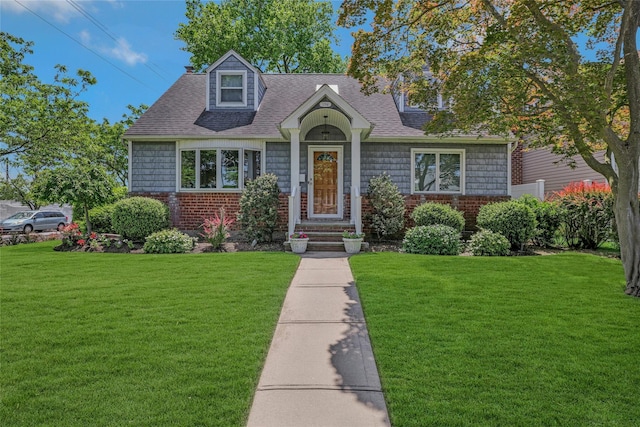 1784 W End Ave, New Hyde Park, NY 11040 - new england style home featuring a front lawn, roof with shingles, and brick siding