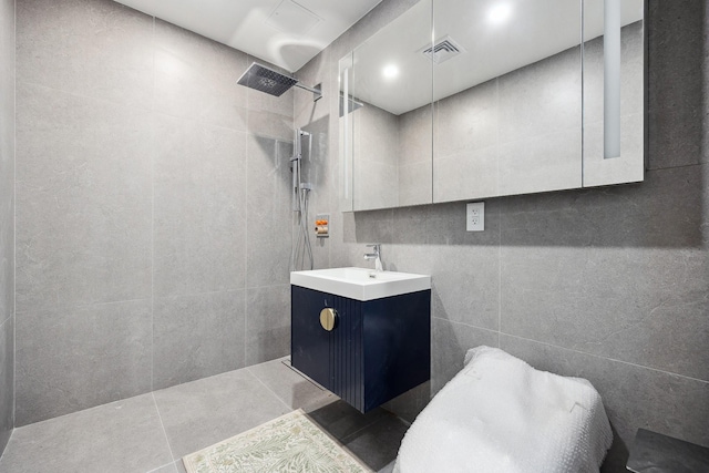 full bath featuring a walk in shower, vanity, tile walls, and pet washing area