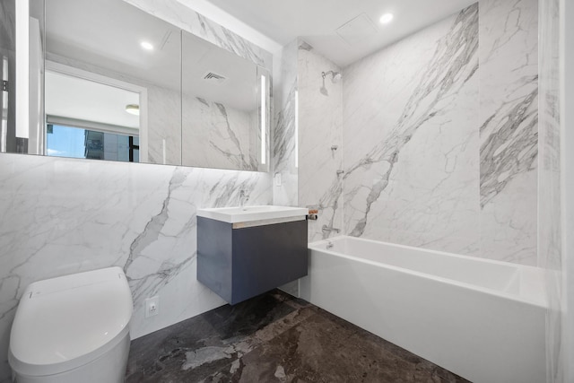 full bath with marble tiled floors, bathing tub / shower combination, vanity, toilet, and tile walls
