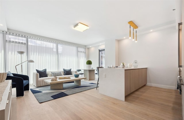 living area with light wood-style floors and baseboards