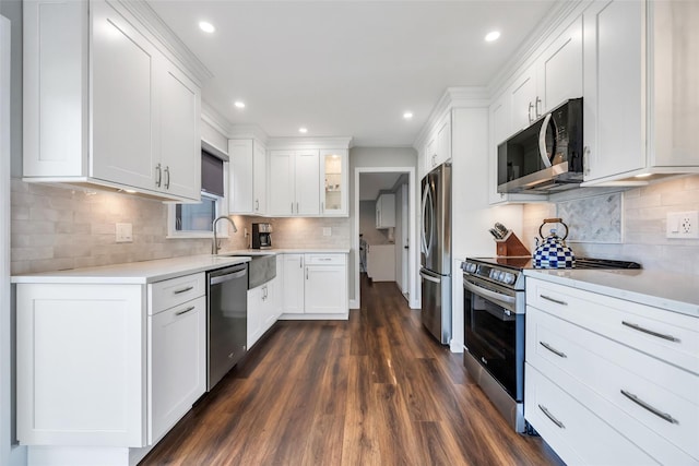 30 Twisting Dr, Lake Grove, NY 11755 - kitchen featuring appliances with stainless steel finishes, white cabinets, dark wood finished floors, backsplash, and recessed lighting