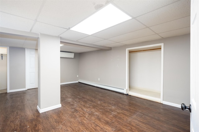 21 Livingston St, Deer Park, NY 11729 - finished below grade area with a baseboard heating unit, a paneled ceiling, wood finished floors, a wall mounted air conditioner, and baseboards