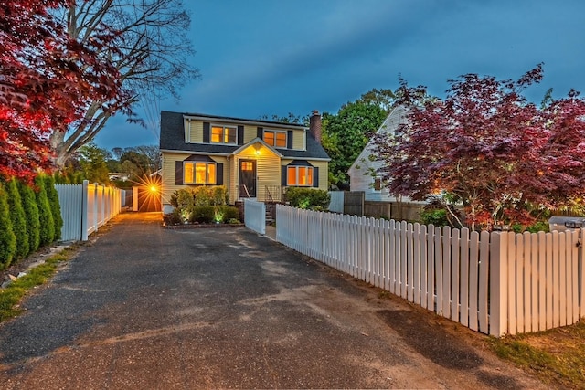 21 Livingston St, Deer Park, NY 11729 - view of front facade featuring a chimney, driveway, and a fenced front yard