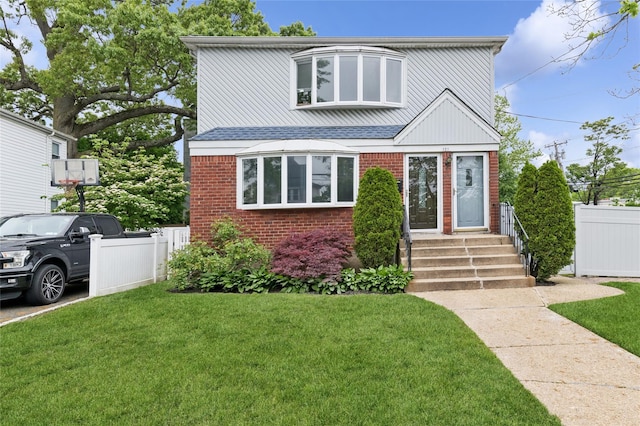view of front facade featuring brick siding, entry steps, and a shingled roof