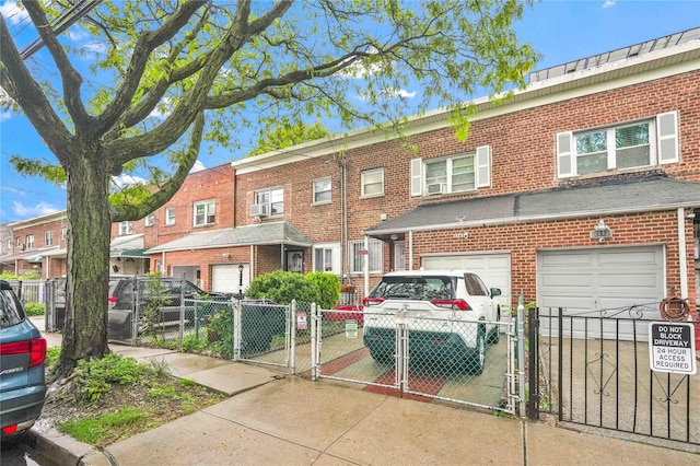 1141 E 213th St, Bronx, NY 10469 - view of front of house with a gate, driveway, brick siding, an attached garage, and a fenced front yard
