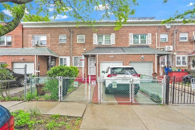 1141 E 213th St, Bronx, NY 10469 - townhome / multi-family property with a gate, brick siding, a fenced front yard, and concrete driveway