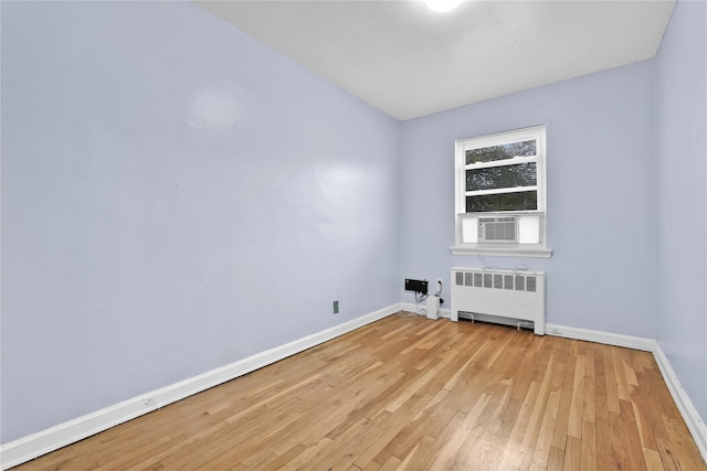 1141 E 213th St, Bronx, NY 10469 - empty room with radiator heating unit, baseboards, and light wood-style flooring