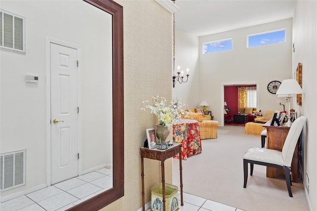 552 Birchwood Park Dr, Middle Island, NY 11953 - corridor featuring healthy amount of natural light, tile patterned flooring, a high ceiling, and a chandelier