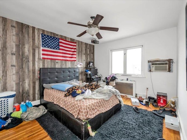 150-31 78th Ave, Flushing, NY 11367 - bedroom featuring wood walls, radiator, wood finished floors, a wall mounted air conditioner, and a ceiling fan