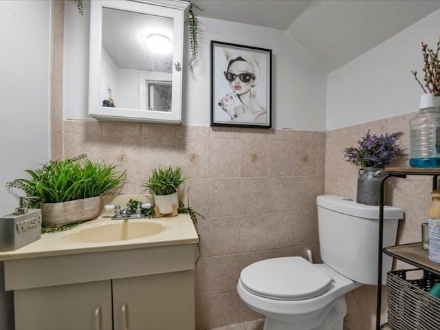 150-31 78th Ave, Flushing, NY 11367 - half bath featuring toilet, tile walls, vanity, lofted ceiling, and a wainscoted wall