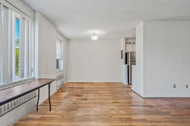 190 W Merrick Rd Unit 4E, Freeport, NY 11520 - empty room featuring wood finished floors and radiator