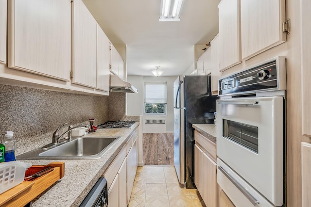 190 W Merrick Rd Unit 4E, Freeport, NY 11520 - kitchen featuring appliances with stainless steel finishes, under cabinet range hood, a warming drawer, light countertops, and decorative backsplash