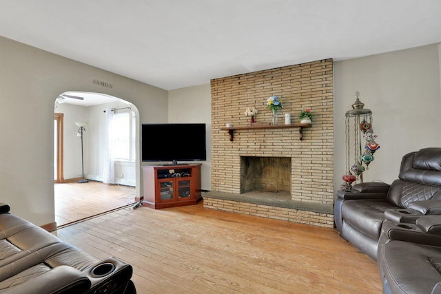 100 Harwich St, Kingston, NY 12401 - living room featuring arched walkways, hardwood / wood-style flooring, and a brick fireplace