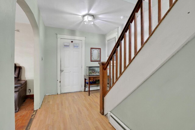 100 Harwich St, Kingston, NY 12401 - entrance foyer featuring arched walkways, stairs, light wood finished floors, and baseboard heating