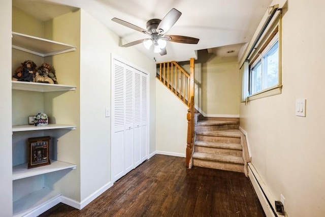 stairs with a baseboard radiator, wood finished floors, ceiling fan, and baseboards