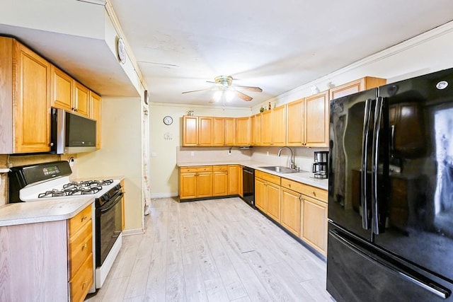 kitchen featuring black appliances, a sink, ceiling fan, light countertops, and baseboards