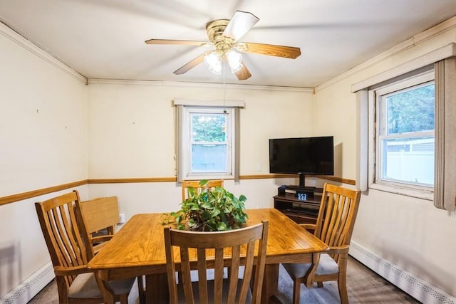 dining room with a baseboard radiator, ornamental molding, a ceiling fan, and baseboards