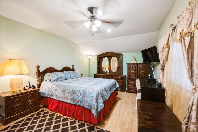 bedroom featuring wood finished floors, lofted ceiling, and ceiling fan