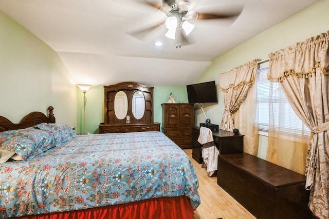 bedroom featuring wood finished floors, lofted ceiling, and a ceiling fan