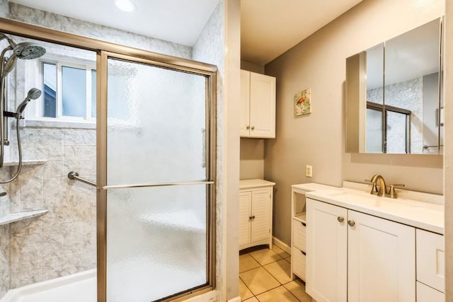 full bathroom with a stall shower, tile patterned floors, and vanity