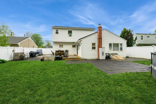 back of property featuring a deck, a patio, and a chimney