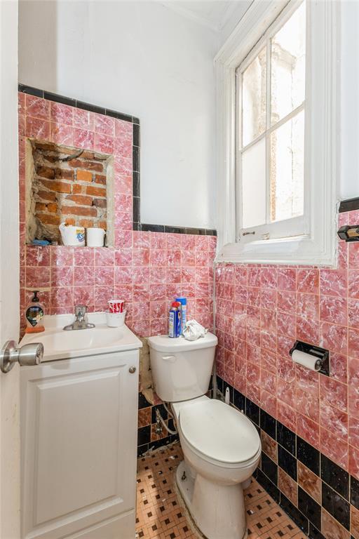 171 Hale Ave, Brooklyn, NY 11208 - bathroom featuring tile walls, toilet, vanity, and a wainscoted wall