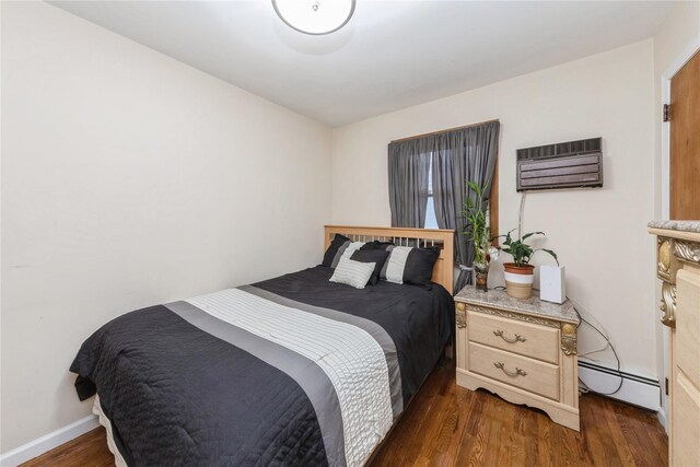 91-10 164th, Howard Beach, NY 11414 - bedroom featuring a baseboard heating unit, a wall mounted air conditioner, and dark wood-style floors