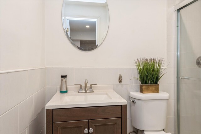 91-10 164th, Howard Beach, NY 11414 - bathroom featuring vanity, toilet, a tile shower, tile walls, and a wainscoted wall